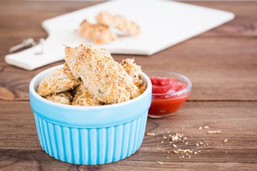 Homemade nuggets from chicken in a bowl on a wooden table