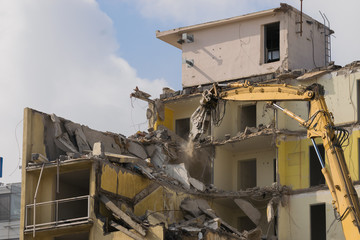 Building demolition: shears cutting through the walls