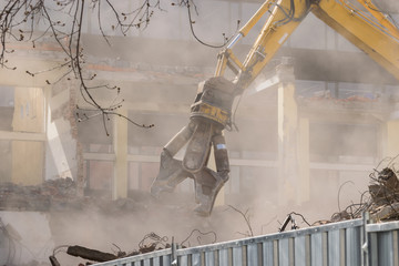 Building demolition: shears cutting through the walls - dusty