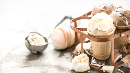 different ice cream in a cone stands in a beautiful stand on a wooden light background, a concept of summer sweets and ice cream