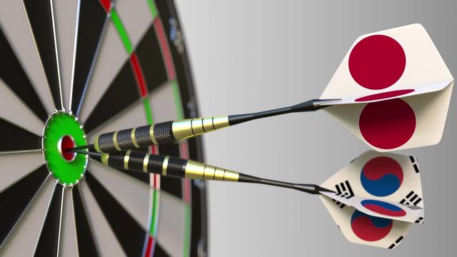 Flags of Japan and Korea on darts hitting bullseye of the target. International cooperation or competition conceptual animation