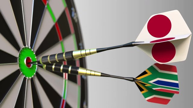 Flags of Japan and South Africa on darts hitting bullseye of the target. International cooperation or competition conceptual animation
