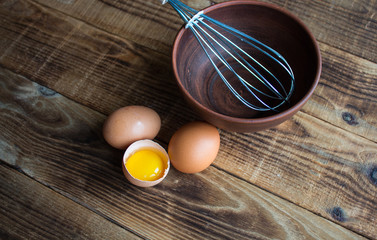 eggs with kitchenware on wooden background