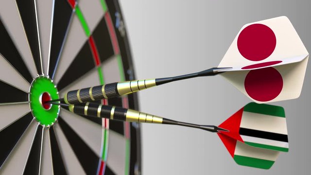 Flags of Japan and the UAE on darts hitting bullseye of the target. International cooperation or competition conceptual animation