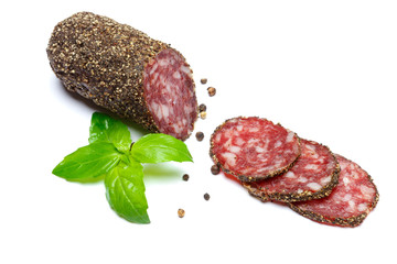Dried organic salami sausage covered with pepper on white background