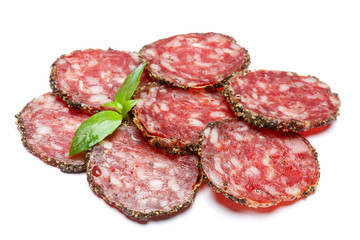 Dried organic salami sausage covered with pepper on white background
