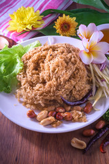 Fluffy spicy catfish with mango sauce Dish dishes on wooden floor (Yum Pla-duke Fu)