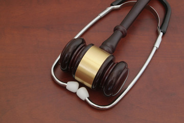 Gavel and stethoscope on wooden table