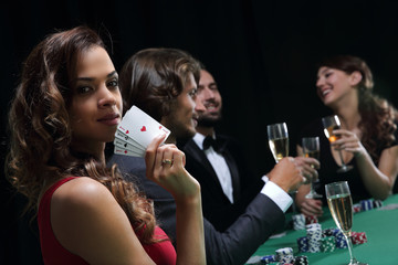 Woman at roulette table holding champagne glass in casino