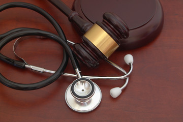 Gavel and stethoscope on wooden background, malpractice concept