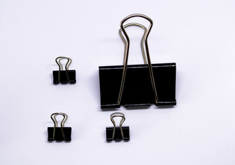 Fototapeta na wymiar Set of paper clips in black, in different sizes on a white background