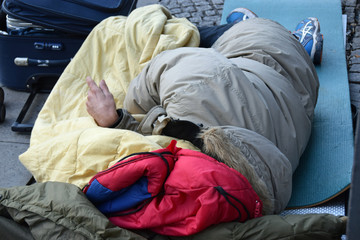 Obdachloser mit Schlafsack und Iso-Matte