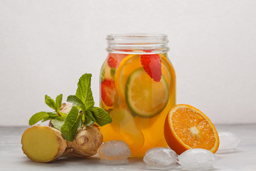 Fototapeta na wymiar Ginger fruity ice tea with mint in a glass jar, white background, copy space. Summer refreshing drink concept.