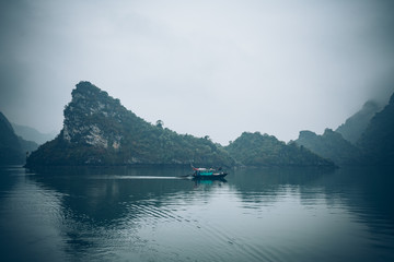 a fisherman in his boat in Ha Long Bay Vietnam
