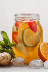 Ginger fruity ice tea with mint in a glass jar, white background, copy space. Summer refreshing drink concept.