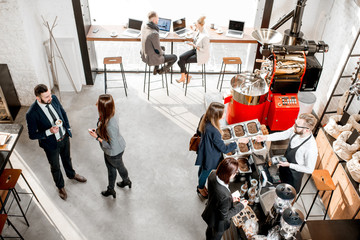 Business people talking and having fun durnig a coffee time in the modern cafe interior. Wide view from above