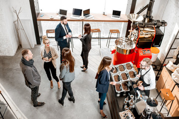 Business people talking and having fun durnig a coffee time in the modern cafe interior. Wide view from above