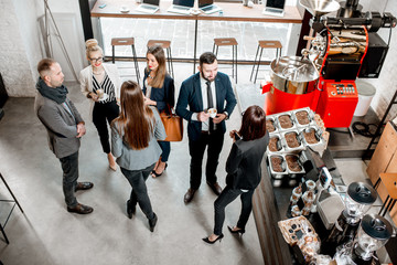 Business people talking and having fun durnig a coffee time in the modern cafe interior. Wide view...
