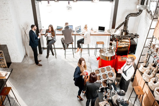Business people talking and having fun durnig a coffee time in the modern cafe interior. Wide view from above
