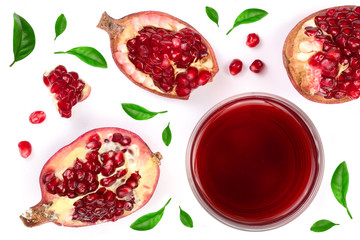 A glass of pomegranate juice with fresh pomegranate fruits decorated with leaves isolated on white background. Top view.