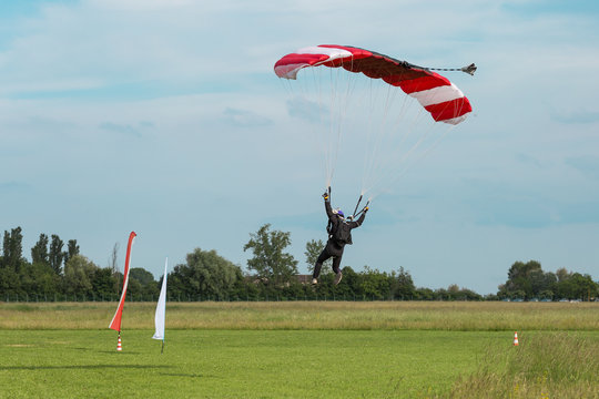 Parachutist with Orange Parachute against Clear Blue Sky
