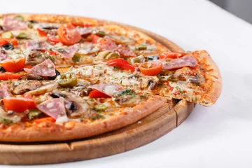 Foto op Plexiglas Italian kitchen and cooking concept. Hot tasty sliced with ham, sausage, jalapenos, mushrooms, tomato. Eat delivery concept. © malkovkosta