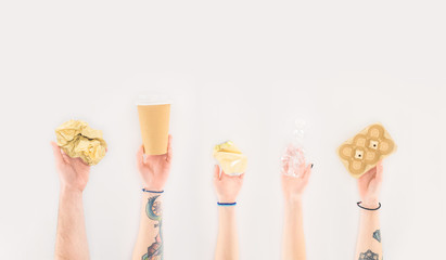 cropped shot of people holding various paper trash isolated on white