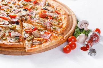 Italian kitchen and cooking concept. Hot tasty sliced with ham, sausage, jalapenos, mushrooms, tomato. Eat delivery concept.