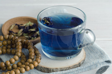 Butterfly pea flower tea cup and mala beads . Asian exotic blue tea background