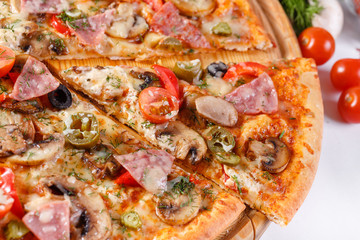 Italian kitchen and cooking concept. Hot tasty sliced with ham, sausage, jalapenos, mushrooms, tomato. Eat delivery concept.