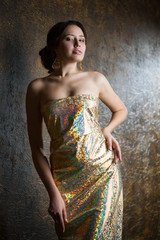 Young beautiful woman in evening gold dress