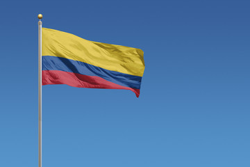 Flag of Columbia in front of a clear blue sky