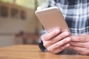 Closeup image of a woman holding , using and looking at smart phone