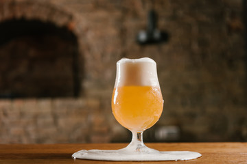 close-up view of delicious fresh beer and foam spilled on table in pub
