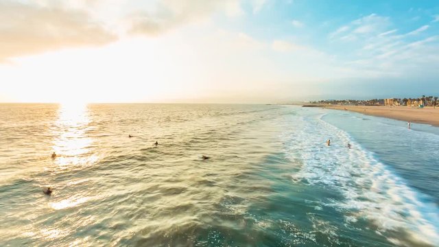 Sunset time-lapse of Venice Beach, California with surfers and swimmers