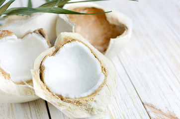 Young coconut on white wooden background. © devmarya