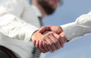 Close-up photo of handshake of two successful businessmen