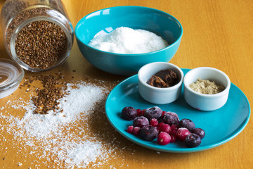 Sweet dessert ingredients on the table, frozen berry, seeds and coconut.