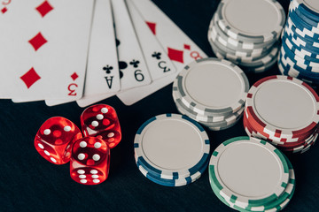 Stacks of chips with dice and playing cards on casino table