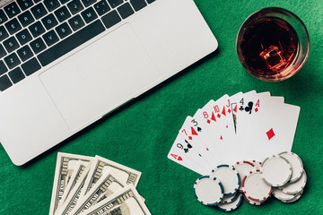 Laptop with dice and gambling chips on keyboard