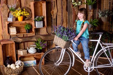 little beautiful girl on a bicycle and smiling on a background of easter decorations