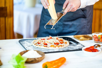closeup hands of chef making fresh homemade traditional italian pizza. wallpaper for pizzeria and cooking food concept