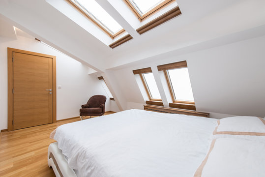 Bedroom interior in luxury loft, attic, apartment with roof windows