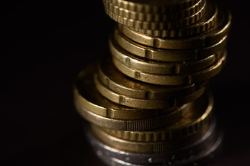 close up view of pile of coins isolated on black