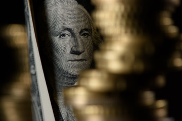 Selective focus of dollar banknote and pile of coins isolated on black