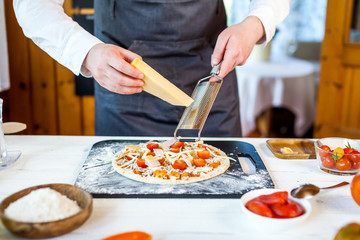closeup hands of chef making fresh homemade traditional italian pizza. wallpaper for pizzeria and cooking food concept