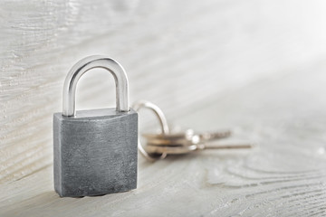 estate concept with symbol of security, lock padlock with key on wooden background.