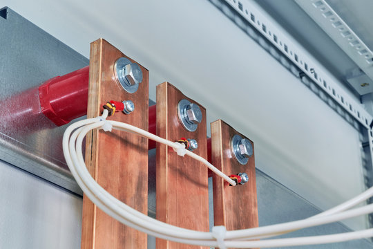 Electrical wires are connected to copper busbars. Busbars are fixed to the circuit Board through red insulators. Electrical equipment is installed in the enclosure of the electrical Cabinet.
