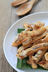 fried squid of Thai seafoods in the white dish on wood floor.