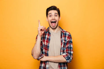 Portrait of a smiling young man pointing finger up